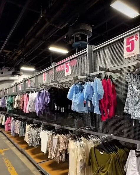 Image de la vidéo officielle Ardene montrant des vêtements en magasin sous des affiches à 5 $